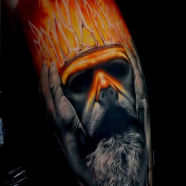 Ein Tattoo im Color Tattoo Style, das das Gesicht eines Königs mit einer feurigen Krone in intensiven Rot- und Orangetönen darstellt.