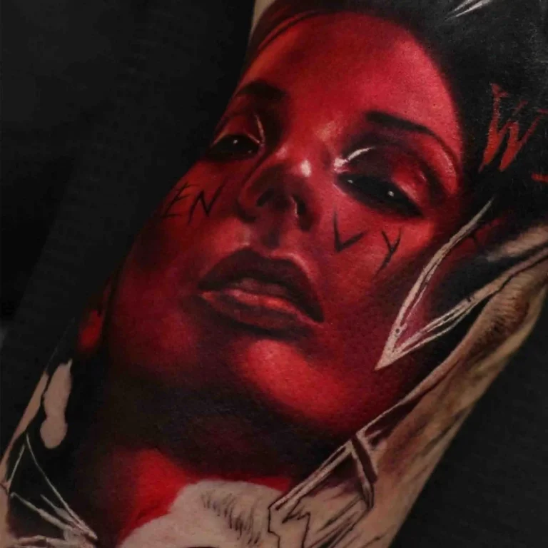 Ein ausdrucksstarkes Tattoo im Color Tattoo Style, das ein rotes Porträt mit intensiven Kontrasten zeigt.
