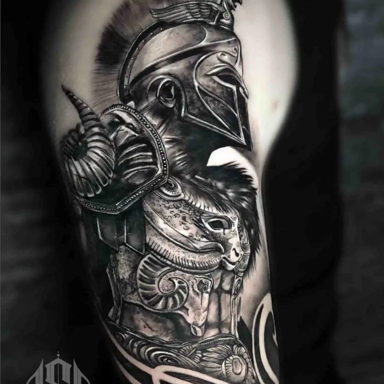Ein Oberarm-Tattoo im Realistic Tattoo Style, das einen antiken griechischen Kriegerhelm mit aufwendigen Rüstungsdetails und Schattenarbeit darstellt.
