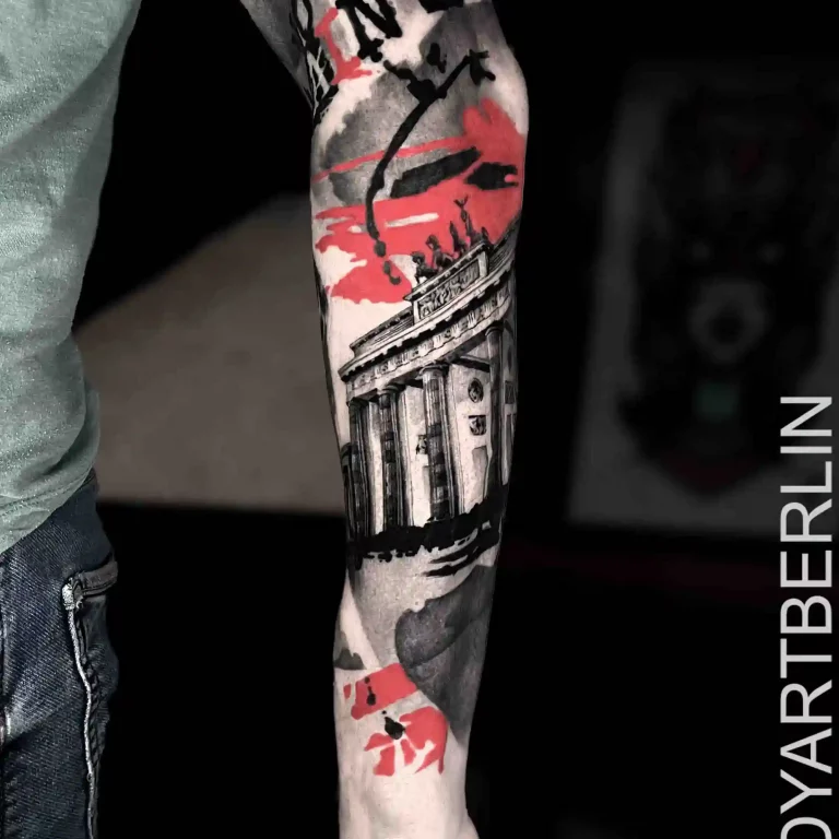 Ein Unterarm-Tattoo im Trash Polka Tattoo Style, das das Brandenburger Tor mit abstrakten roten und schwarzen grafischen Akzenten darstellt.