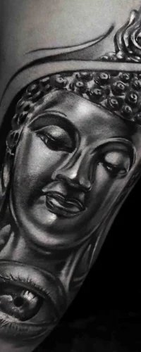 Ein realistisches Tattoo im Color Tattoo Style, das einen Buddha mit feinen Schattierungen und ein detailliertes Auge in faszinierenden Farbtönen zeigt.