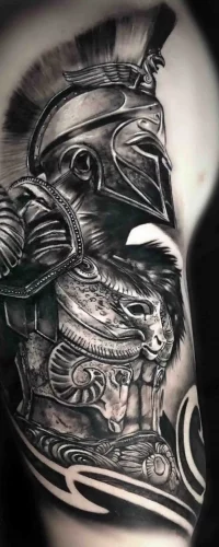 Ein Oberarm-Tattoo im Realistic Tattoo Style, das einen antiken griechischen Kriegerhelm mit aufwendigen Rüstungsdetails und Schattenarbeit darstellt.
